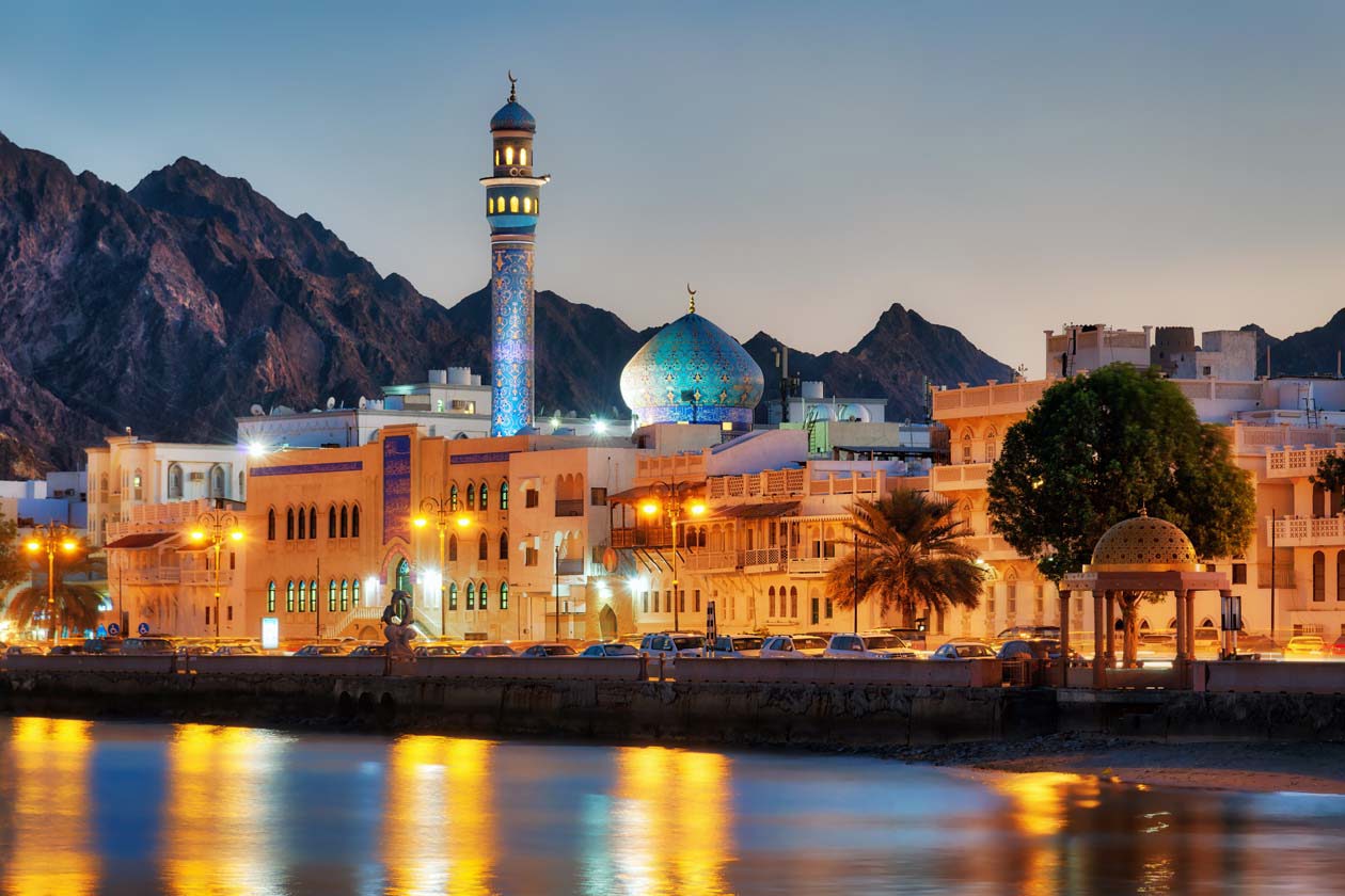 Muscat affacciata sul mare al tramonto con le Montagne Hajar sullo sfondo Copyright © Sisterscom.com / Depositphotos