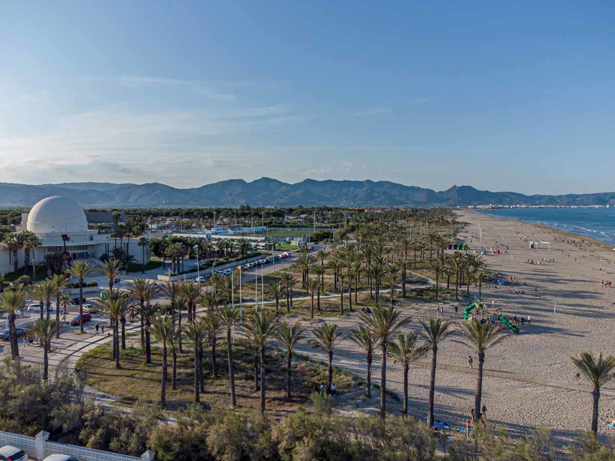 Playa del Pinar: la spiaggia con il mare e il Planetario e le motagne all'orizzonte a Castellon de la Plana. Foto ad esclusivo uso editoriale: Copyright © Castelló Turismo